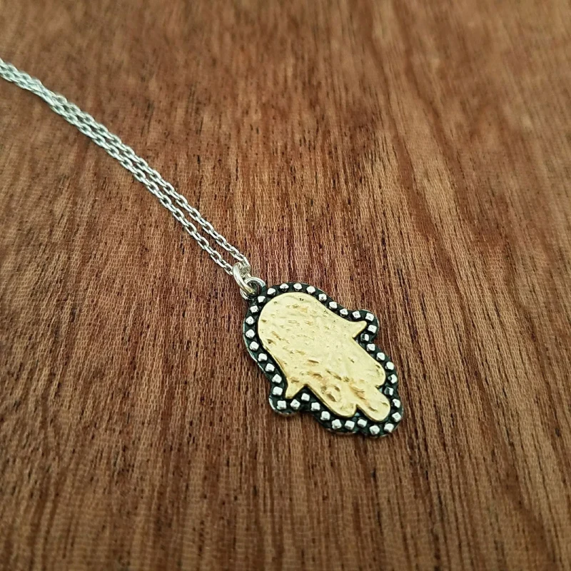 gold hamsa necklace with two tone charm